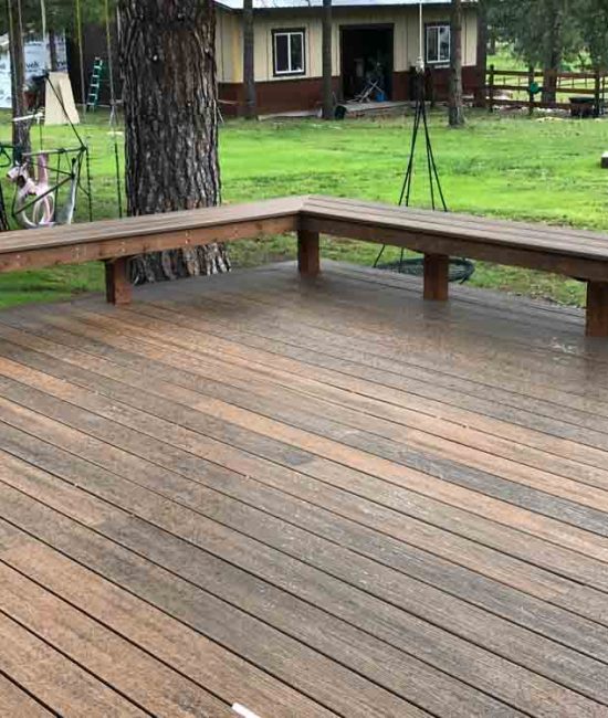 A wood deck with wood benches on edge of the perimeter