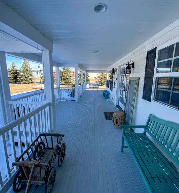 A wide deck of a house near a barn