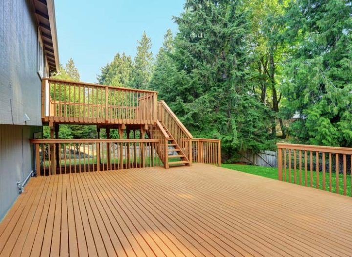 Two floors of deck in a house made of wood decking, railings, and railing posts