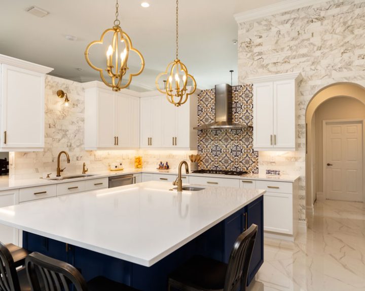 An elegant kitchen interior with artistic pendant lights, decorative tile backsplash, and ceramic countertops